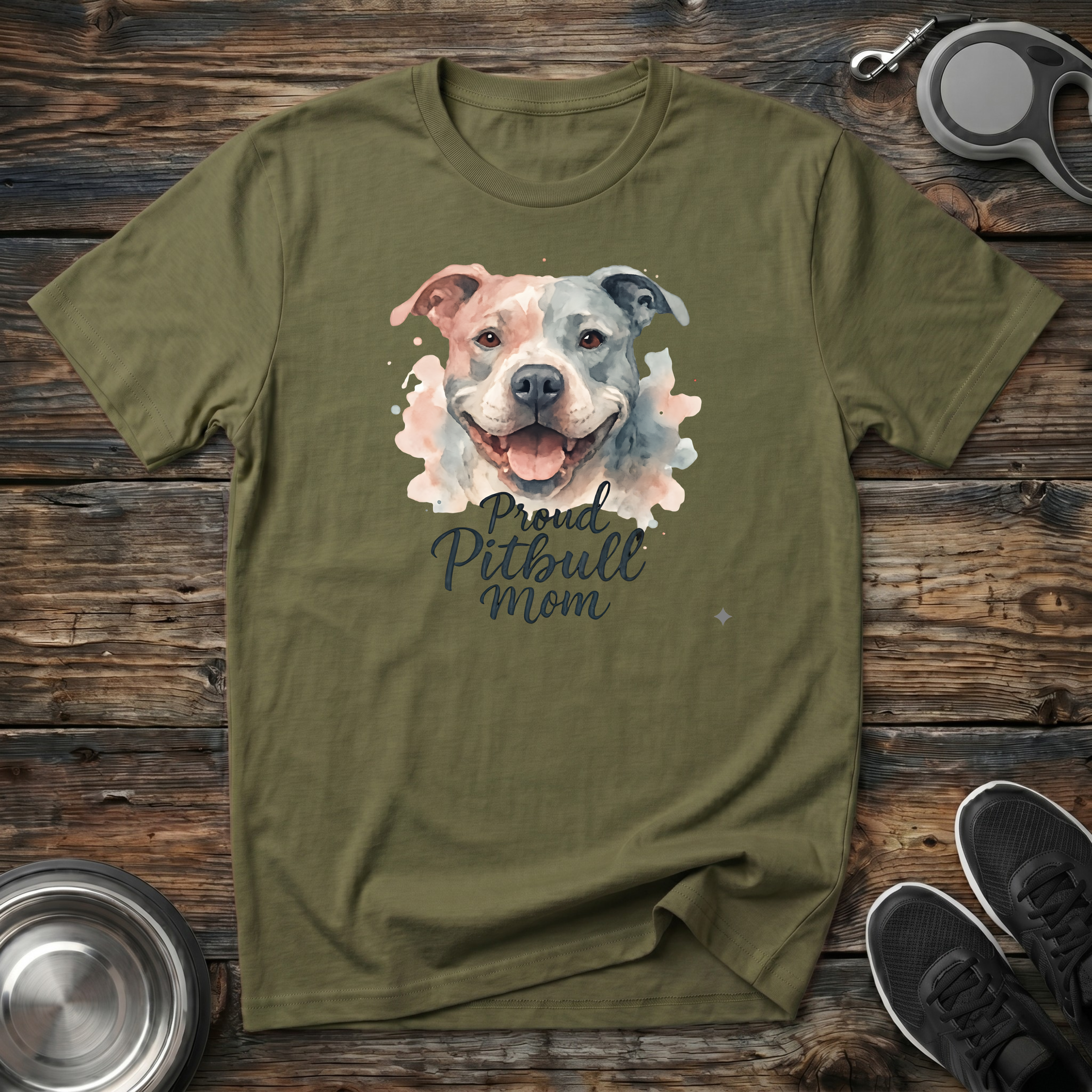 Military green unisex t-shirt with soft watercolor Pitbull portrait in blush pink and grey tones and elegant "Proud Pitbull Mom" dark script lettering — beautiful bully breed lover gift tee