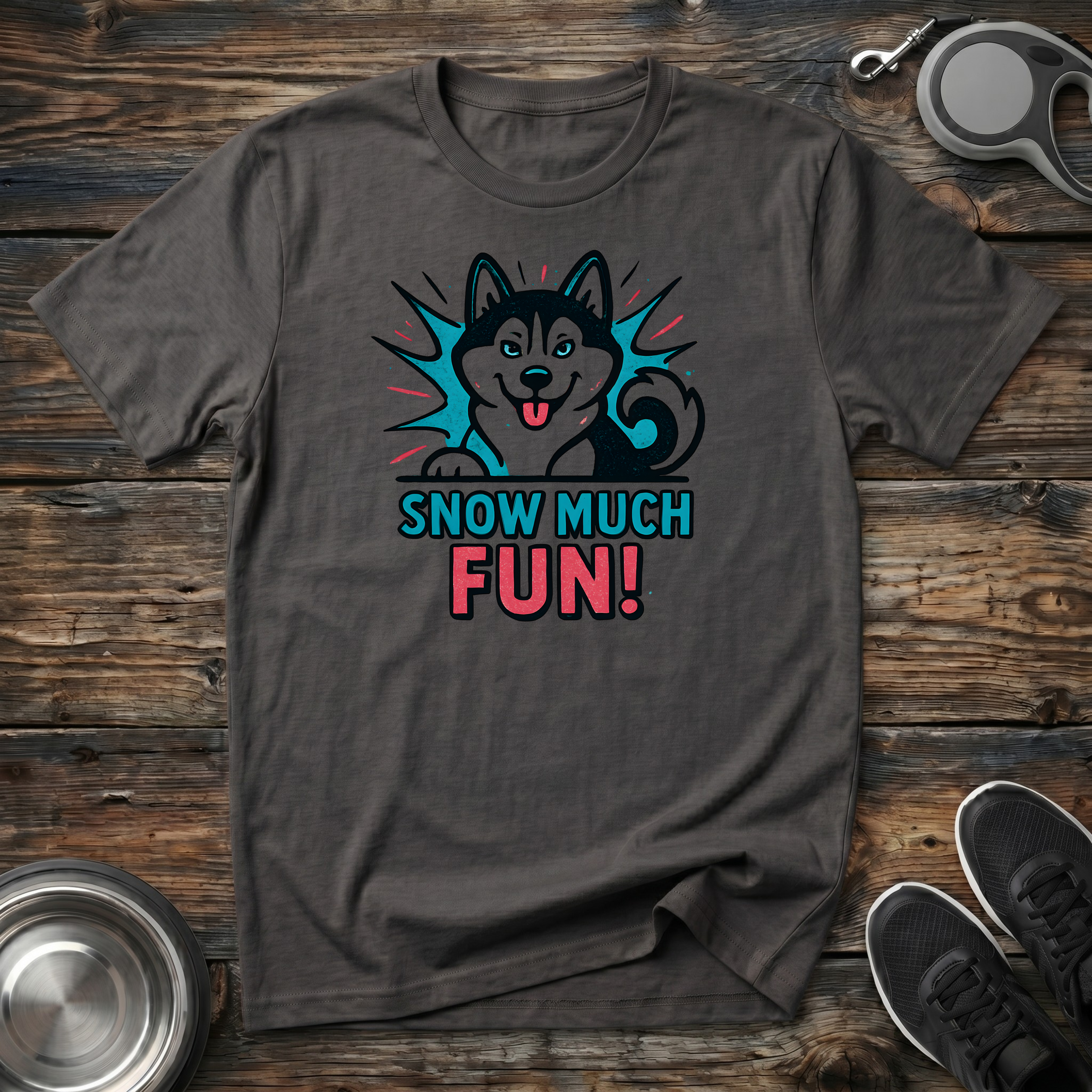 Dark charcoal heather unisex t-shirt with bold comic-style Siberian Husky starburst graphic in vivid teal and coral with "Snow Much Fun!" lettering — funny Husky lover gift tee for winter dog moms dads