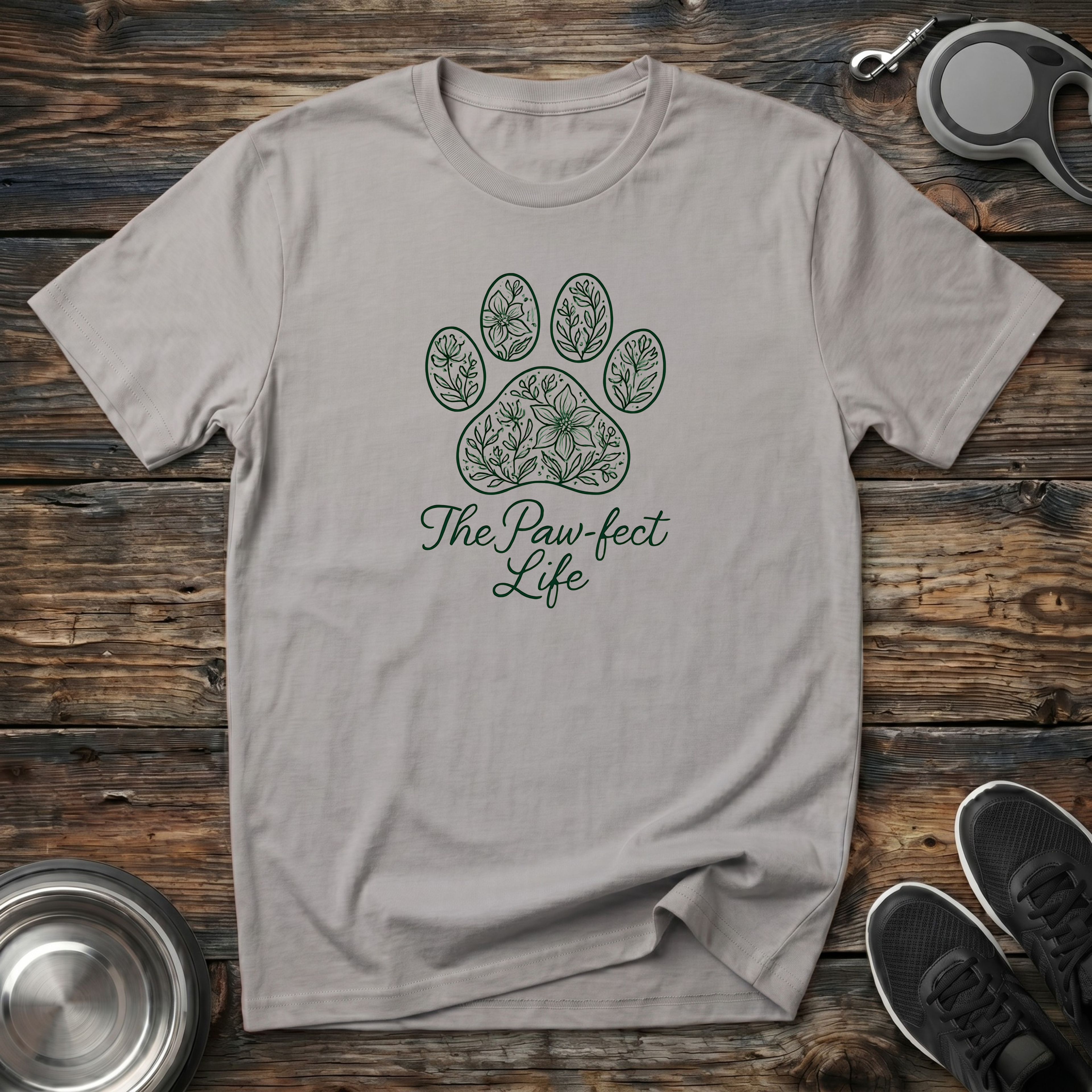 Sand beige unisex dog lover t-shirt with dark green botanical floral paw print graphic and "The Paw-fect Life" script — elegant pet parent gift tee