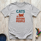 Soft grey unisex t-shirt with bold teal "Cats" and burnt orange "Before People" retro block lettering and vintage cat playing with yarn graphic — funny cat lover gift tee for introverts