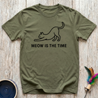 Military green unisex t-shirt with minimalist black line art stretching cat graphic and bold "Meow Is The Time" lettering — funny minimalist cat lover gift tee for cat moms and dads