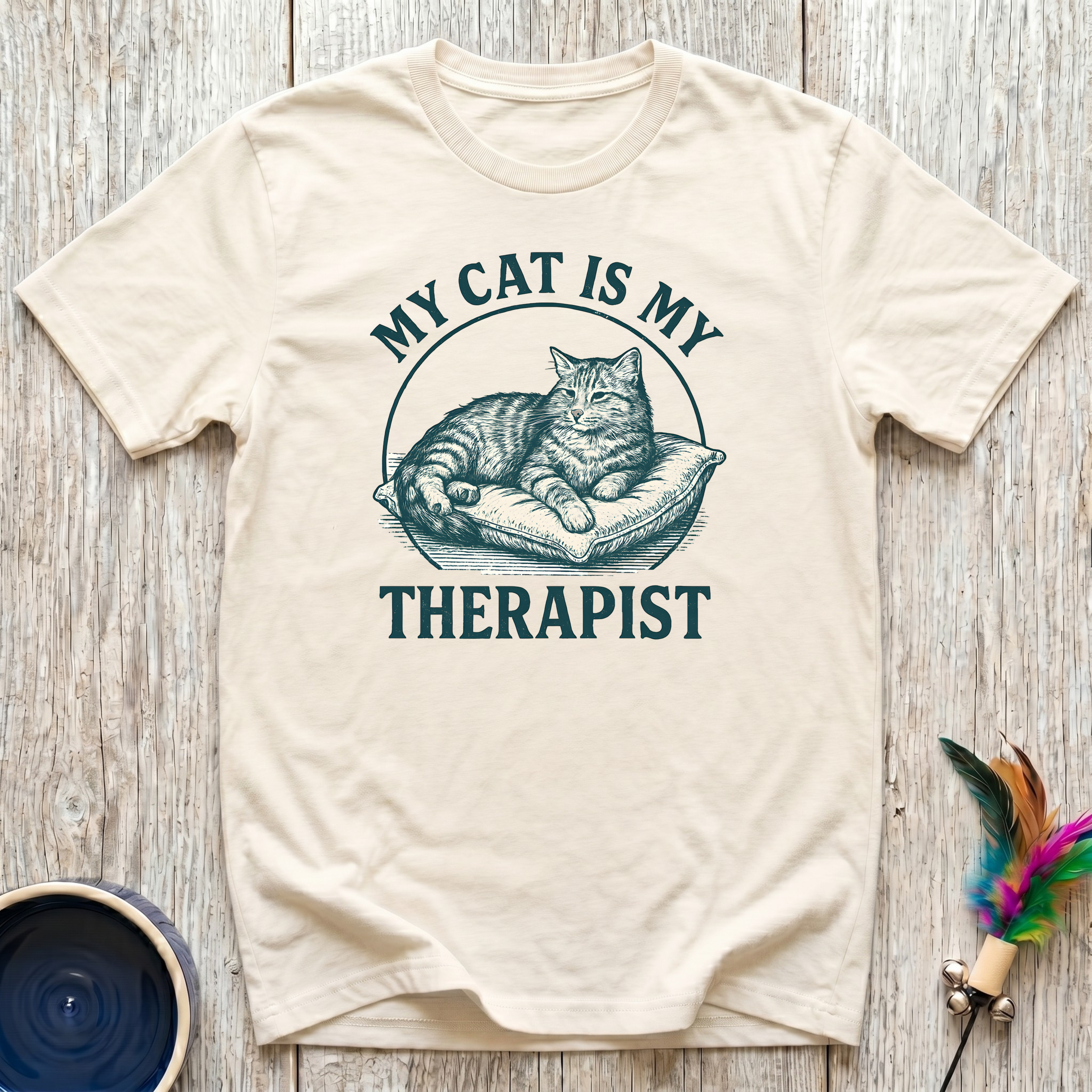 My Cat is My Therapist cream t-shirt with stunning vintage
engraving style tabby cat on cushion in rich teal lettering,
funny emotional cat lover tee and cat mom mental health gift
